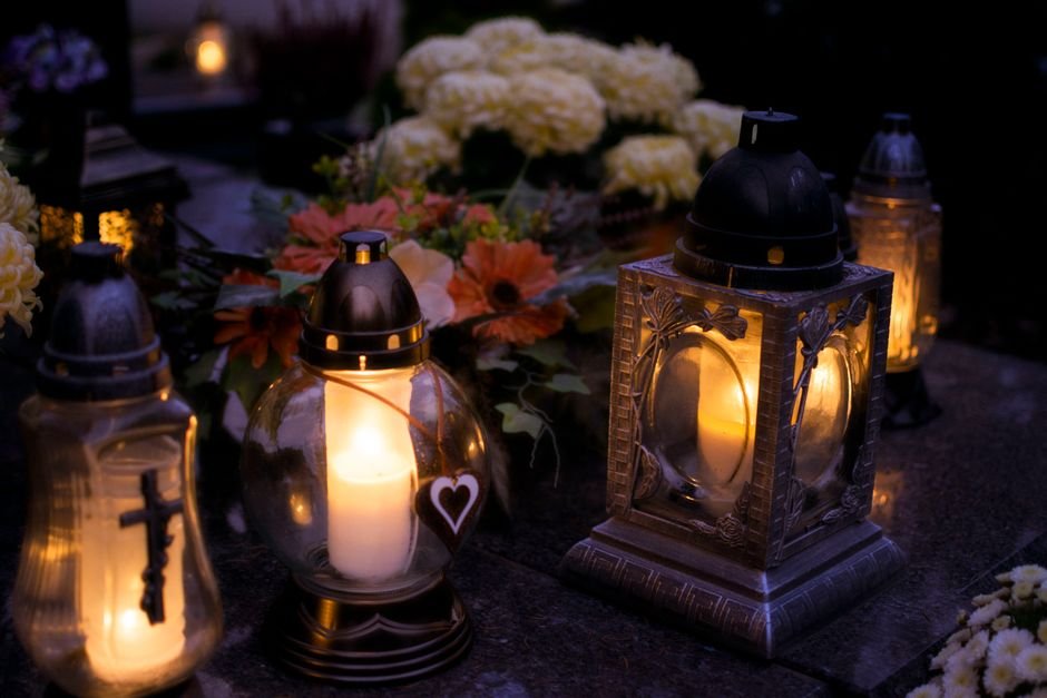 Candles and flowers at a grave, illustrating the prayer for the dead